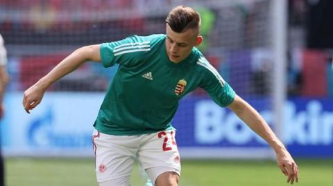 Szabi Schon tries to control the ball while wearing his Hungarian national team kit.