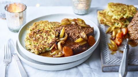 Beef brisket with potato latkes on a white plate