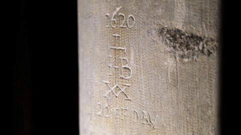 Historic graffiti showing a cross with the date '1620' above it, the letters I and B to the sides, a double xx below and the date '20 of May'.
