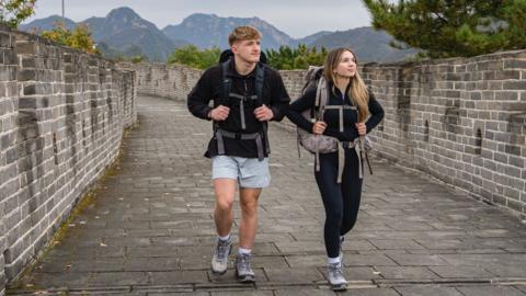 Fin an Sioned, two competitors on Race Across the World, walk along a brick path in China.