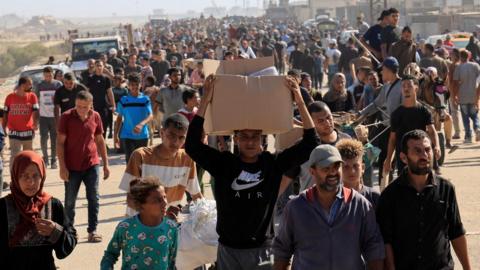Palestinians seeking aid gather near an aid distribution site run by the US-backed Gaza Humanitarian Foundation, in Rafah, in the southern Gaza Strip (27 November 2025)