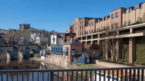 Raised two storey buildings looking down on a bridge over a river