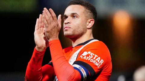 Carlton Morris applauds the Luton supporters following their defeat at QPR