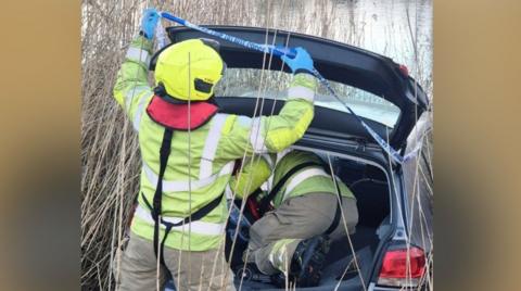 Firefighters in the back of a car in the water