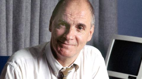 Brian Hayes posing and smiling in a radio studio