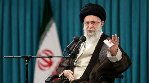 Iran's supreme leader Ali Khamenei speaks from behind a microphone.