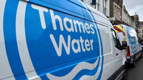 Thames Water vans are parked on a road as repair and maintenance work takes place