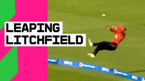 Phoebe Litchfield leaps backwards while pushing the ball away to ensure that it doesn't fly over the boundary