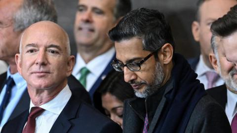 Jeff Bezos, Sundar Pichai and Elon Musk standing next to eachother at the second inauguration of President Donald Trump 