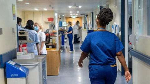 Nurse or doctor walking through hospital