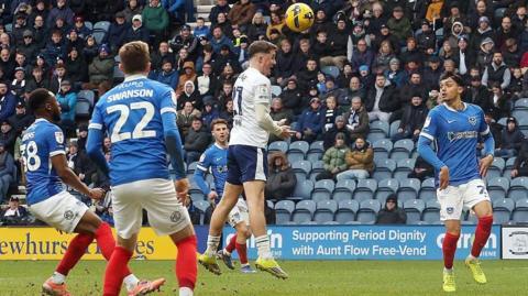 Preston North End striker Alfie Devine heads the ball into the Portsmouth net.