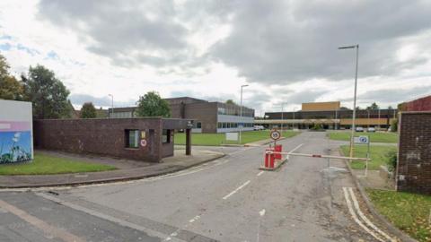 A Google image screengrab of the former EDF offices in Barnett Way in Barnwood. The image shows the entrance to the site, with two barriers for vehicular access. The offices can be seen in the background.