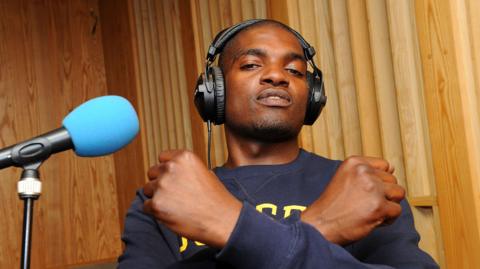 Dot Rotten crosses his arms across his chest while recording a session at the BBC's Maida Vale Studios in 2011