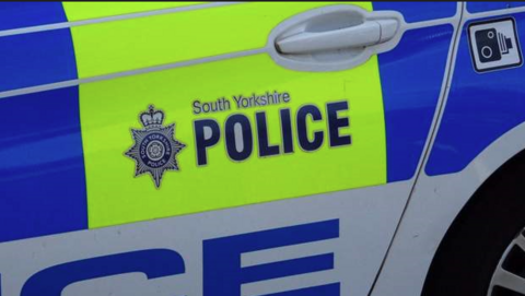 An image of the rear of a police marked car with the South Yorkshire Police logo in blue on a luminous yellow background