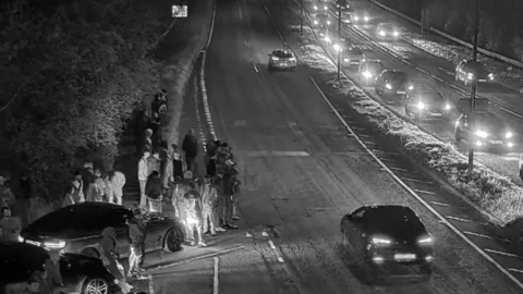 A black and white image of cars at a cruising event