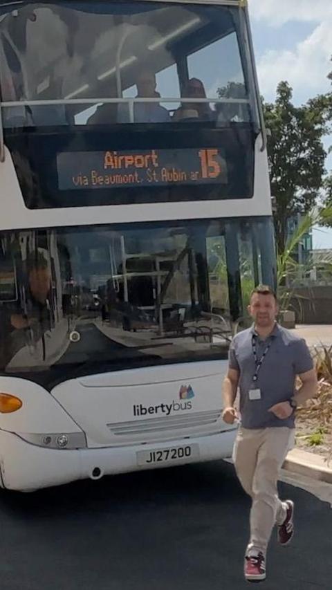 A man walks in front of a bus in Jersey