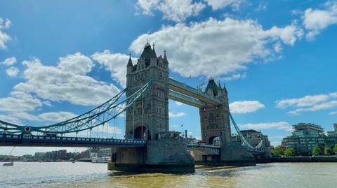 London's Tower Bridge lit by bright sunlight under a fairweather sky