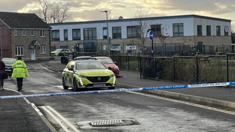 Police cars and some police tape outside the primary school