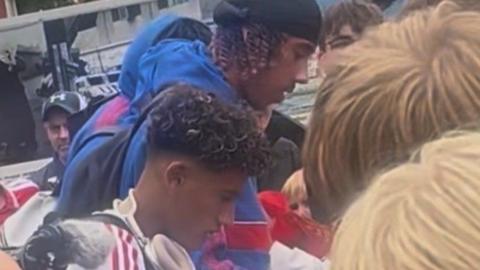 Manchester United's JJ Gabriel and Leny Yoro signing autographs after arriving in Norway on Thursday