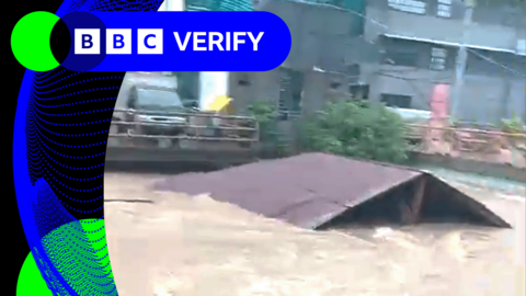 A roof being swept away in floodwater