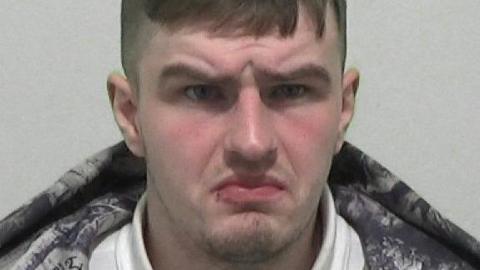 Mugshot of Daniel Gaunt. He has a faint goatee beard and short brown hair. His brow is furrowed and he looks confused. 