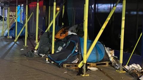 Tents underneath scaffolding outside a Liverpool city centre building at night