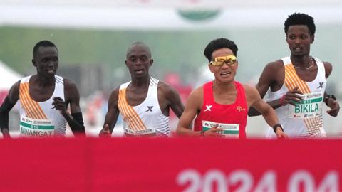 Chinese runner He Jie, Ethiopian Dejene Hailu Bikila and Kenyans Robert Keter and Willy Mnangat take part in the Beijing half marathon