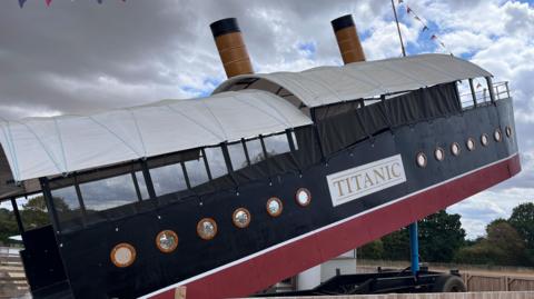 An outdoor hydraulic slide designed to look like Titanic. It has a red and blue exterior with a large sign that reads "Titanic".