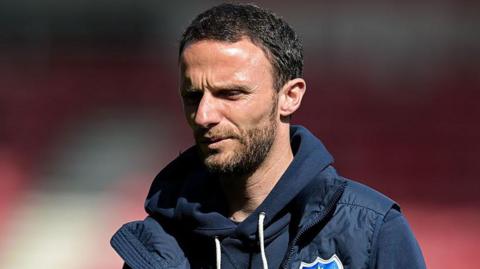 Jordan Williams pictured in a hooded sweatshirt and Portsmouth gilet.