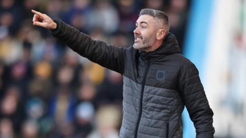 Ryan Dicker points to the Crewe Alexandra players from the touchline during a game