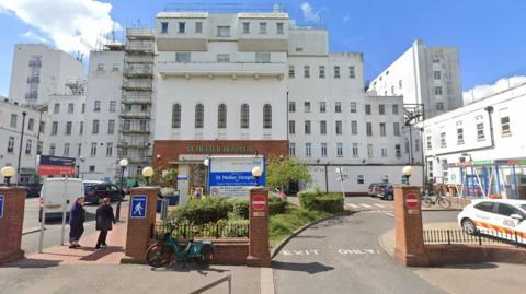 A general view of the exterior of St Helier Hospital shows white building with red brick entrance and wall