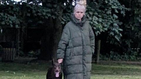 A woman in a long green puffer jacket. 