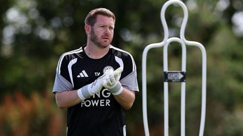Tom Weal on the Leicester training ground wearing a black training top and white goalkeeping gloves