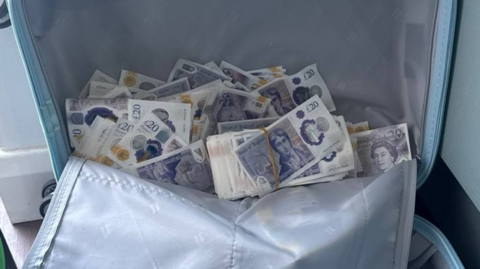 A suitcase full of counterfeit £20 bank notes.