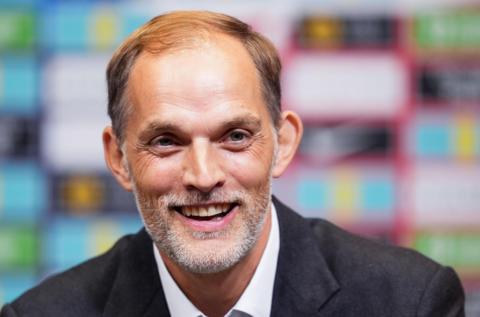 German manager Thomas Tuchel smiling in a grey blazer