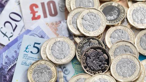 Pound coins and bank notes - stock photo