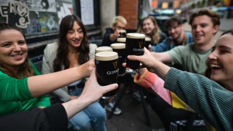 People enjoy drinking Guinness outside a pub in Dublin, Ireland