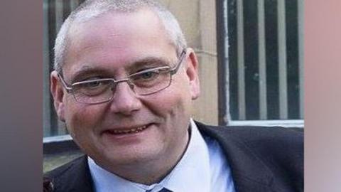 Close up image of a smiling David Daintree wearing a suit