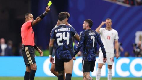 Argentina's Rodrigo de Paul is shown a yellow card during the World Cup semi-final against England