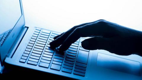 A close up of a hand typing on a laptop computer keyboard