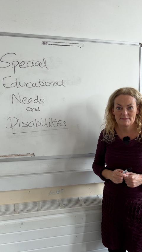 Women with blonde, wavy hair standing in front of a whiteboard with Special Educational Needs and Disabilities written on it.