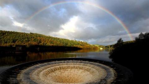 A rainbow arches over Ladybower Reservoir.