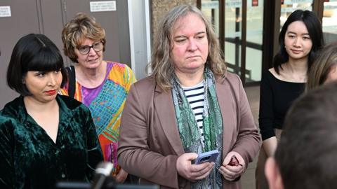 Roxanne Tickle (centre) looks on as she is surrounded by people while speaking to press outside the Federal Court of Australia in Sydney on 23 August.