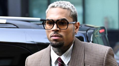 U.S. singer Chris Brown, who has been charged with inflicting grievous bodily harm in what prosecutors said was an "unprovoked attack" on a music producer at the Tape nightclub in central London in 2023, walks outside the Southwark Crown Court in London, Britain, July 11, 2025.