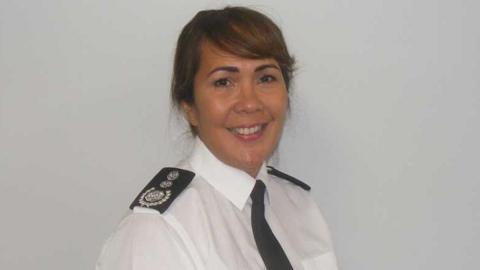 Buckinghamshire chief fire officer Louise Harrison. She is wearing a white shirt, a black tie and on her shoulders can be seen black epaulettes, one of which can be seen with the fire service log. She is turned towards the viewer with her left shoulder forward. She has dark hair pulled back, a fringe over her forehead and is smiling