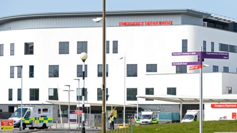 A large white building with ambulances parked outside