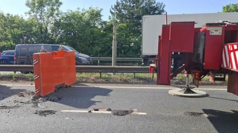 A crane ballast weight on the A11 near Thetford in Norfolk. Part of the road surface has been damaged from the object.