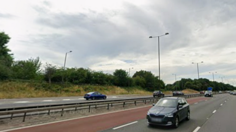 Motorway with taxi lane in red and cars driving in other lanes both ways
