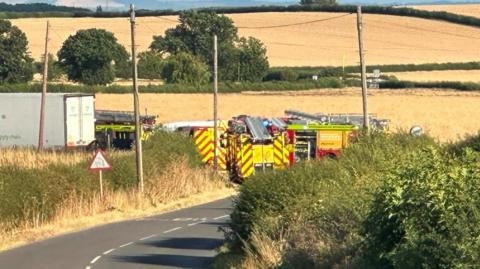 Multiple fire engines parked on a road in Bilsthorpe, surrounded by fields