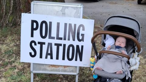 Baby in pushchair at polling station